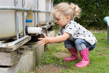 squatting - Little girl washing hands under outdoor cistern spigot Stock Photo - Premium Royalty-Free, Code: 632-08698505