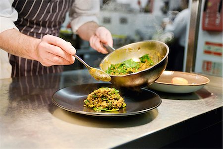 serving gourmet food - Restaurant chef placing cooked lentil dish on plate Stock Photo - Premium Royalty-Free, Code: 632-08698595