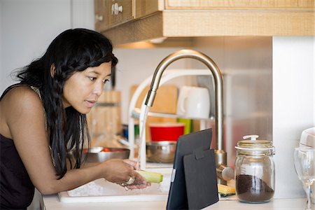 simsearch:632-05760692,k - Woman using digital tablet while preparing food at home Stock Photo - Premium Royalty-Free, Code: 632-08886636