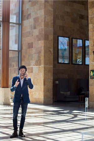 simsearch:859-06710917,k - Casually dressed businessman talking on cell phone in lobby Stock Photo - Premium Royalty-Free, Code: 632-08886712