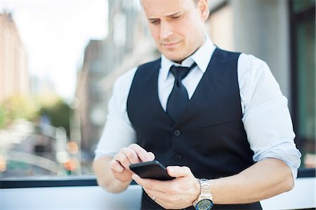 simsearch:649-07520071,k - Businessman text messaging with smartphone Stock Photo - Premium Royalty-Free, Code: 632-08886824