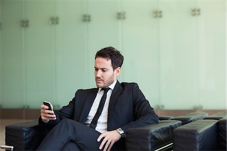 simsearch:6109-06685044,k - Executive looking at cell phone with concerned look Stock Photo - Premium Royalty-Free, Code: 632-08886952