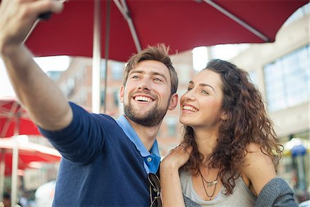 simsearch:632-07674444,k - Couple posing for a selfie at an outdoor cafe Stock Photo - Premium Royalty-Free, Code: 632-08886989