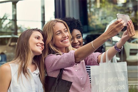 Friends using smartphone to take a selfie while out shopping Stock Photo - Premium Royalty-Free, Code: 632-08993522