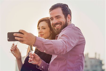 simsearch:632-07674444,k - Couple posing with champagne for selfie Stock Photo - Premium Royalty-Free, Code: 632-08993665