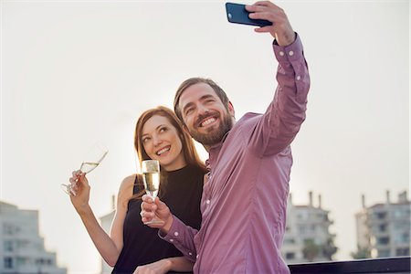 simsearch:632-07674444,k - Couple posing with champagne for selfie Stock Photo - Premium Royalty-Free, Code: 632-08993666