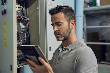 Man working in electrical control cabinet Stock Photo - Premium Royalty-Free, Code: 632-09021503