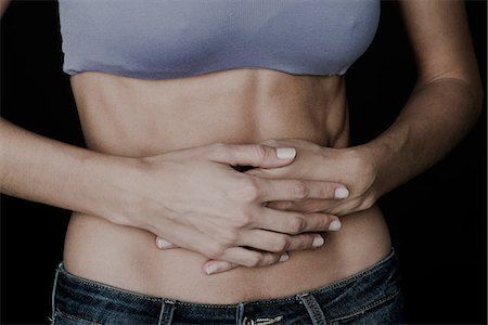 stomachache - Woman clutching bare stomach with hands Stock Photo - Premium Royalty-Free, Code: 632-09040050