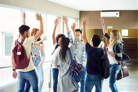 simsearch:614-06973669,k - Group of students standing in circle in corridor with hands raised in the air Stock Photo - Premium Royalty-Free, Code: 632-09158026