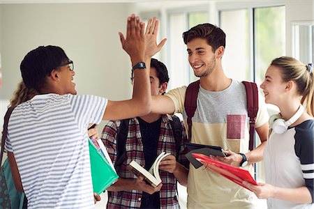 simsearch:614-06973669,k - Students giving each other a high-five in corridor Stock Photo - Premium Royalty-Free, Code: 632-09158070