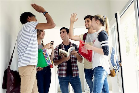 simsearch:614-06973669,k - Students giving each other a high-five in corridor Stock Photo - Premium Royalty-Free, Code: 632-09158071