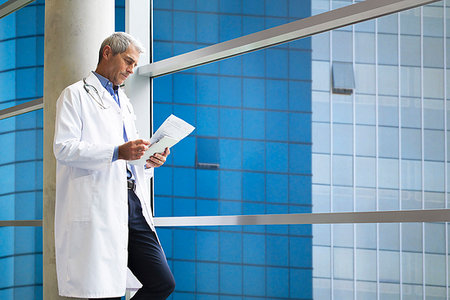 reporting - Doctor reading medical reports Stock Photo - Premium Royalty-Free, Code: 632-09192123