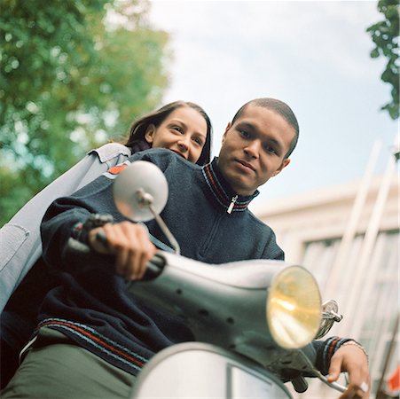 simsearch:695-03382482,k - Young man and young woman on motor scooter, waist up, tilt Stock Photo - Premium Royalty-Free, Code: 632-01137627