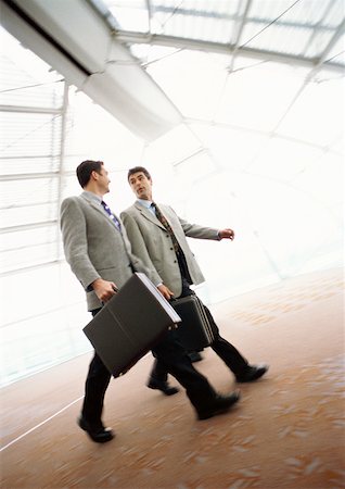 Businessmen walking together with briefcases, indoors. Stock Photo - Premium Royalty-Free, Code: 632-01138178