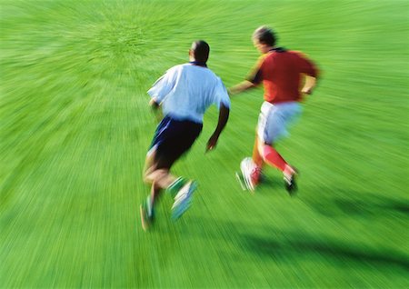 Two soccer players running for ball, blurred Stock Photo - Premium Royalty-Free, Code: 632-01145766