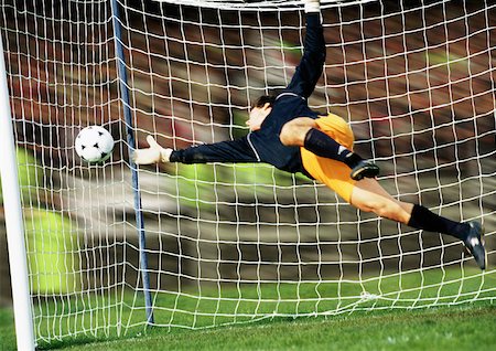diving (not water) - Goal keeper reaching for soccer ball. Stock Photo - Premium Royalty-Free, Code: 632-01145809