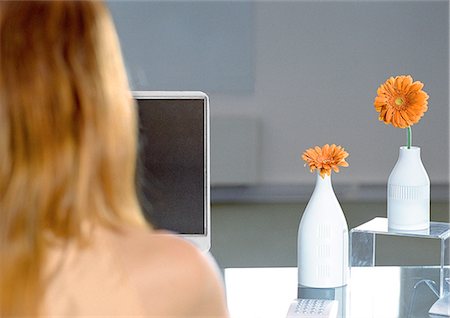 Woman at desk with orange flowers, rear view Stock Photo - Premium Royalty-Free, Code: 632-01146233