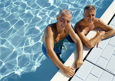 Two mature men resting on side of swimming pool, portrait, elevated view Stock Photo - Premium Royalty-Free, Code: 632-01146652