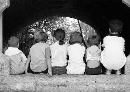 Children sitting under arch, viewed from the back, b&w Stock Photo - Premium Royalty-Free, Code: 632-01141656