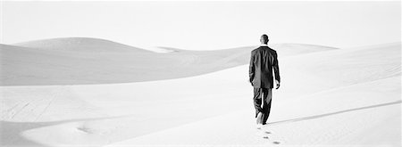 simsearch:695-03386286,k - Businessman walking across dunes, rear view, b&w, panoramic view Stock Photo - Premium Royalty-Free, Code: 632-01143353