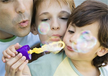 simsearch:632-05604245,k - Father having fun with his two chiildren, blowing soap bubbles together, portrait, extreme close-up Stock Photo - Premium Royalty-Free, Code: 632-01155129