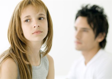 sad girls - Preteen girl looking away, older brother in background Stock Photo - Premium Royalty-Free, Code: 632-01155186