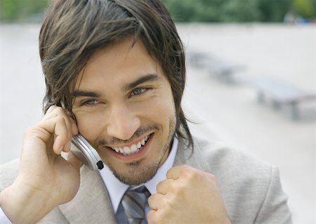 simsearch:695-03376228,k - Businessman using cell phone, smiling, and clenching fist Stock Photo - Premium Royalty-Free, Code: 632-01155493