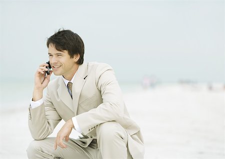 simsearch:695-03376228,k - Businessman crouching on beach, using cell phone Stock Photo - Premium Royalty-Free, Code: 632-01155537