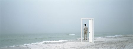 simsearch:632-03500607,k - Man standing on beach, framed by doorframe Stock Photo - Premium Royalty-Free, Code: 632-01156097
