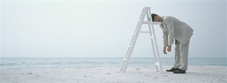 simsearch:632-03500607,k - On beach, businessman sleeping standing up, resting head on ladder Stock Photo - Premium Royalty-Free, Code: 632-01156124