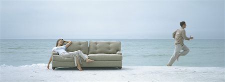simsearch:632-03500607,k - On beach, woman reclining on sofa while man runs away Stock Photo - Premium Royalty-Free, Code: 632-01156127