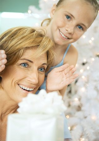 Girl surprising woman with christmas present Stock Photo - Premium Royalty-Free, Code: 632-01156381
