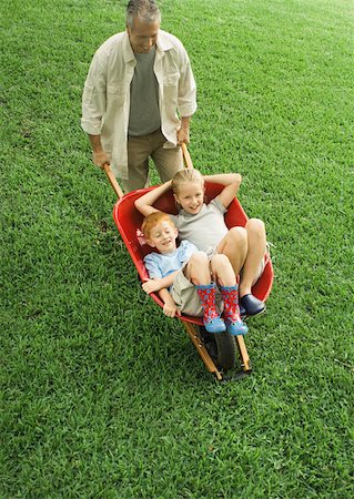 Father pushing two children in wheelbarrow Stock Photo - Premium Royalty-Free, Code: 632-01156546