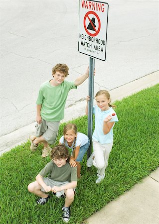 Suburban children grouped around neighborhood watch sign Stock Photo - Premium Royalty-Free, Code: 632-01156950