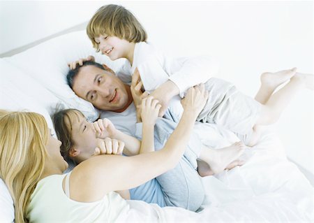 simsearch:695-03378605,k - Parents with daughter and son in bed, smiling Stock Photo - Premium Royalty-Free, Code: 632-01151552