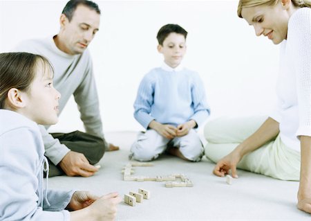 simsearch:649-06812444,k - Girl and boy with parents playing dominoes on floor Foto de stock - Sin royalties Premium, Código: 632-01151563