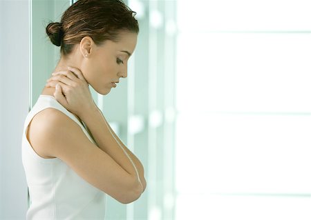 Woman looking down, holding neck Stock Photo - Premium Royalty-Free, Code: 632-01162586