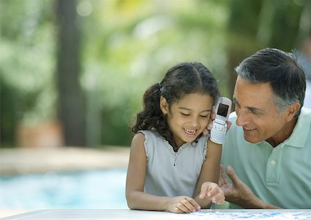 simsearch:632-01193783,k - Mature man holding up cell phone to granddaughter's ear Stock Photo - Premium Royalty-Free, Code: 632-01194006