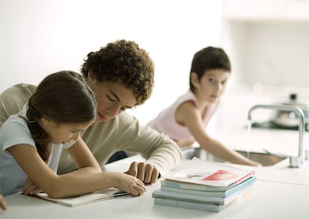 Adolescent boy helping sister with homework Foto de stock - Sin royalties Premium, Código: 632-01193804