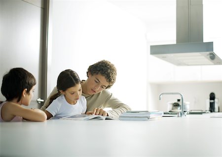 Adolescent boy helping little sister with homework Stock Photo - Premium Royalty-Free, Code: 632-01193802