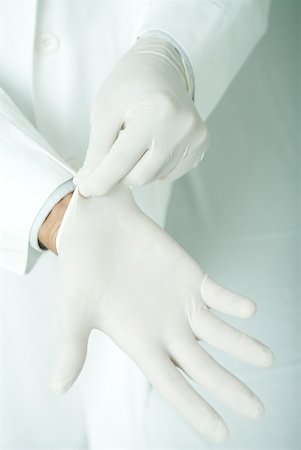 Doctor putting on latex gloves Stock Photo - Premium Royalty-Free, Code: 632-01277324