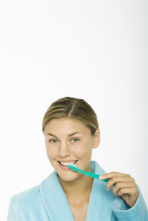 simsearch:696-03395895,k - Young woman brushing teeth, looking at camera Stock Photo - Premium Royalty-Free, Code: 632-01277881