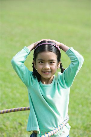 simsearch:632-01193783,k - Girl playing with plastic hoop, smiling at camera Stock Photo - Premium Royalty-Free, Code: 632-01270856