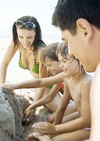 Family playing in sand on beach together Stock Photo - Premium Royalty-Free, Code: 632-01271124