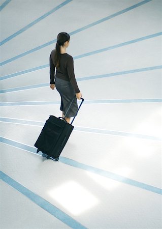 simsearch:695-03386286,k - Woman walking with suitcase, full length, high angle view Stock Photo - Premium Royalty-Free, Code: 632-01271646