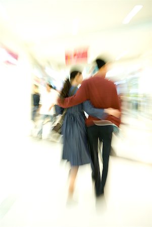 deformity - Couple walking through shopping mall, rear view, full length, blurred motion Stock Photo - Premium Royalty-Free, Code: 632-01271764