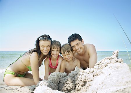 Family sitting on beach near pile of sand, portrait Stock Photo - Premium Royalty-Free, Code: 632-01271830