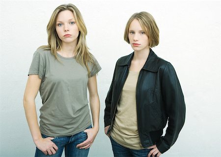 Teenage girls standing side by side with hands on hips, looking at camera, portrait Stock Photo - Premium Royalty-Free, Code: 632-01271855