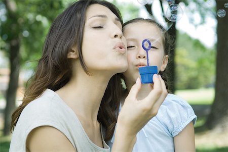 Girl and mother blowing bubbles together Stock Photo - Premium Royalty-Free, Code: 632-01380252