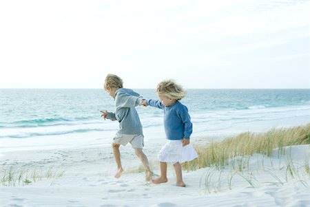 Sister and brother holding hands on beach Stock Photo - Premium Royalty-Free, Code: 632-01380355